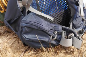 Aan weerszijde van de Osprey Atmos AG 50 vind je twee zakken met rits voor een muesli-reep, een gelletje of een kompas.